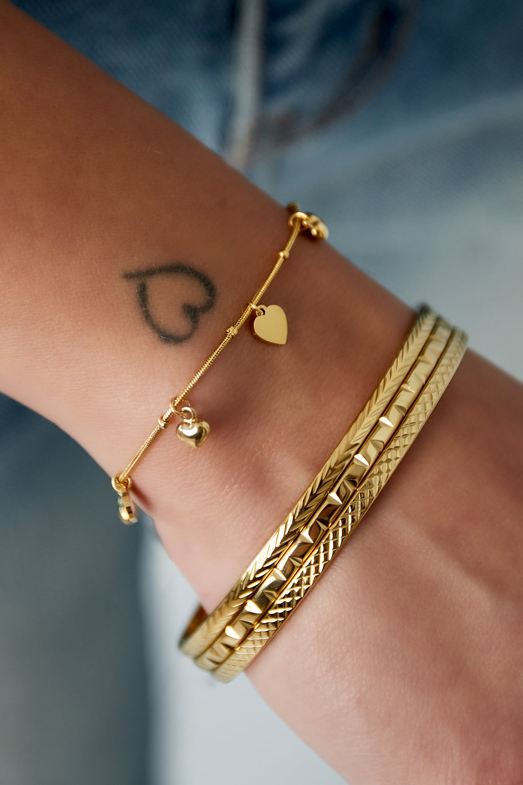 Tiny - bedelarmband Goud aan pols
