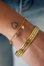Tiny - bedelarmband Goud aan pols